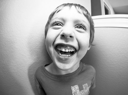A young boy grinning and showing all of his teeth